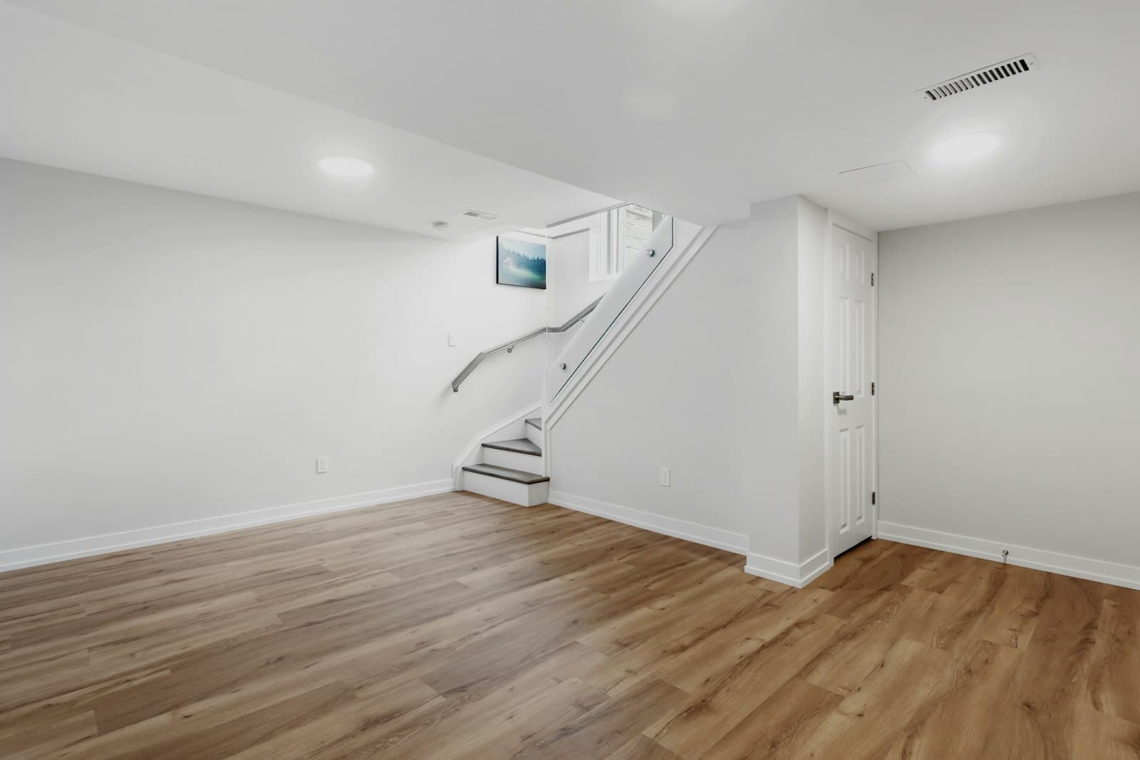 Clean, renovated basement with new flooring and staircase