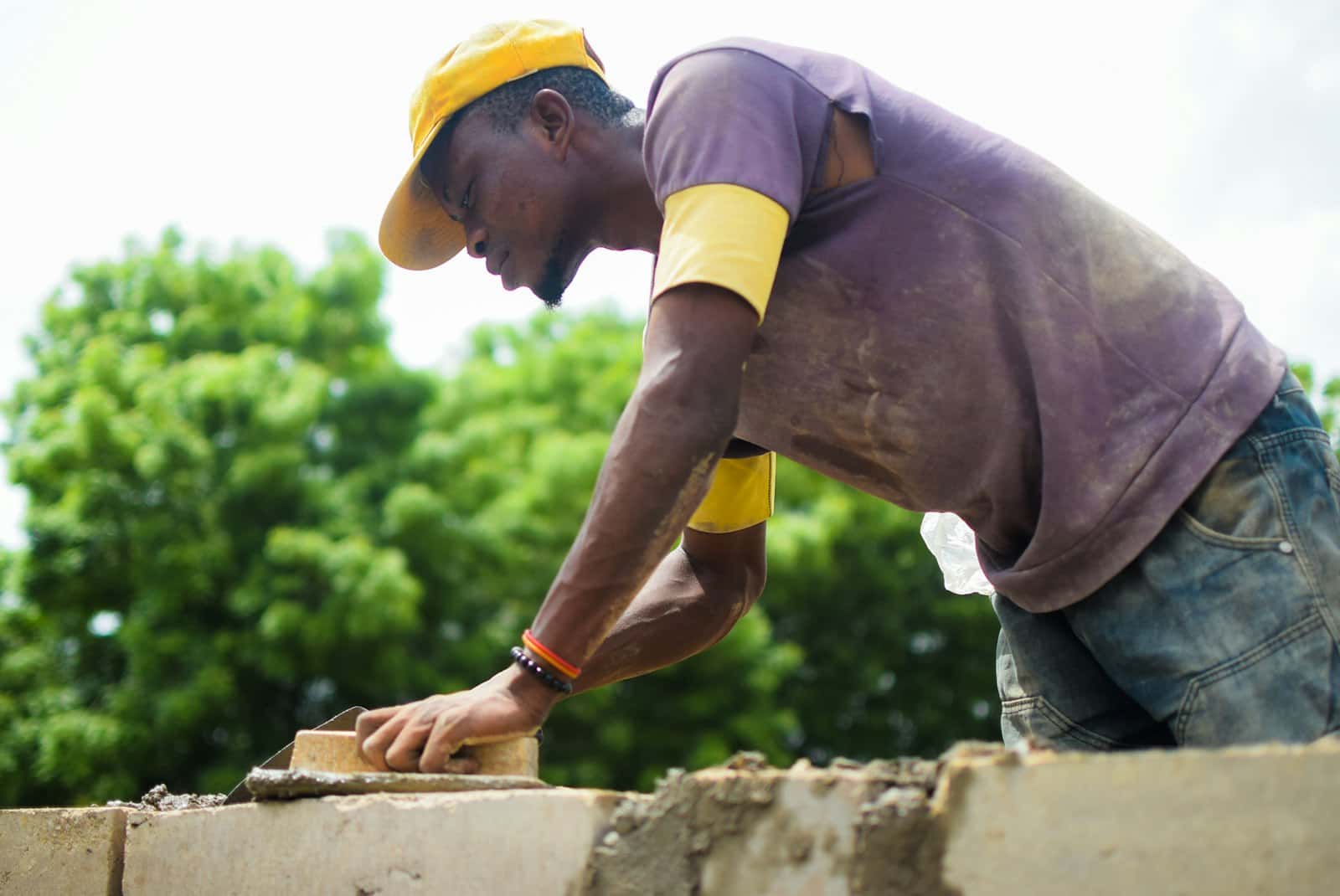 Bricklayer laying a new course of bricks